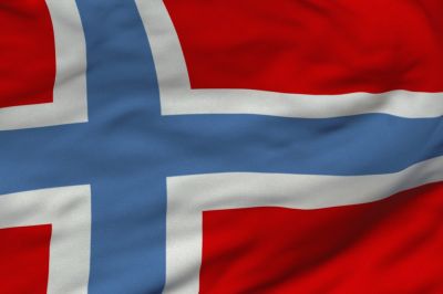 The flag of Norway is red with an indigo blue Scandinavian cross outlined in white that extends to the edges of the flag